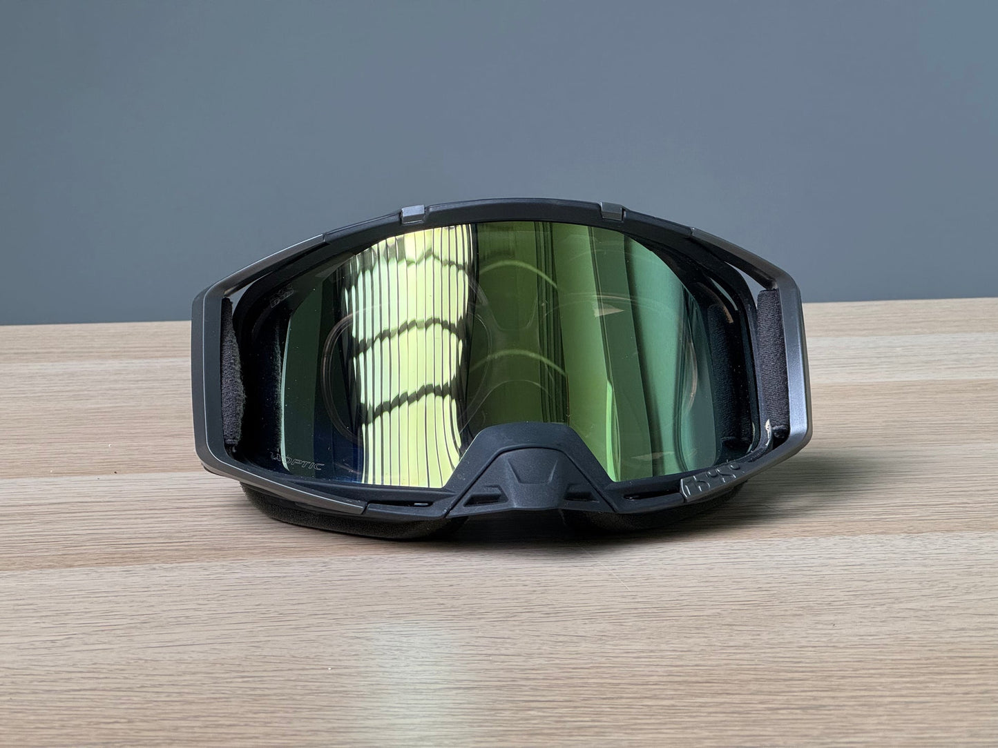 IXS Trigger goggle front view on wooden surface with prescription insert visible, yellow-green lens