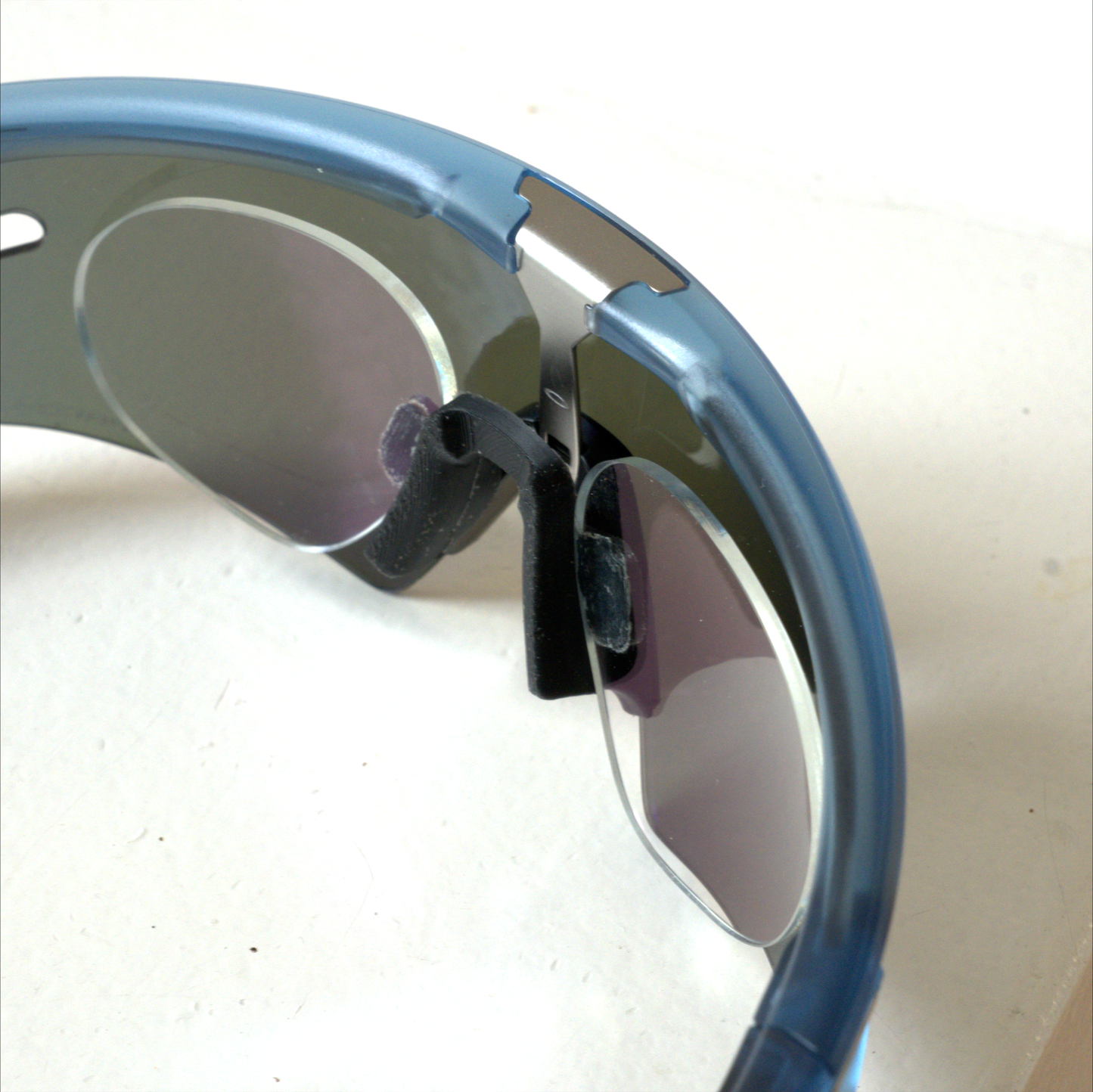 Oakley Sphaera prescription insert seen from inside at an angle, showing the rimless lenses and nosepiece mount
