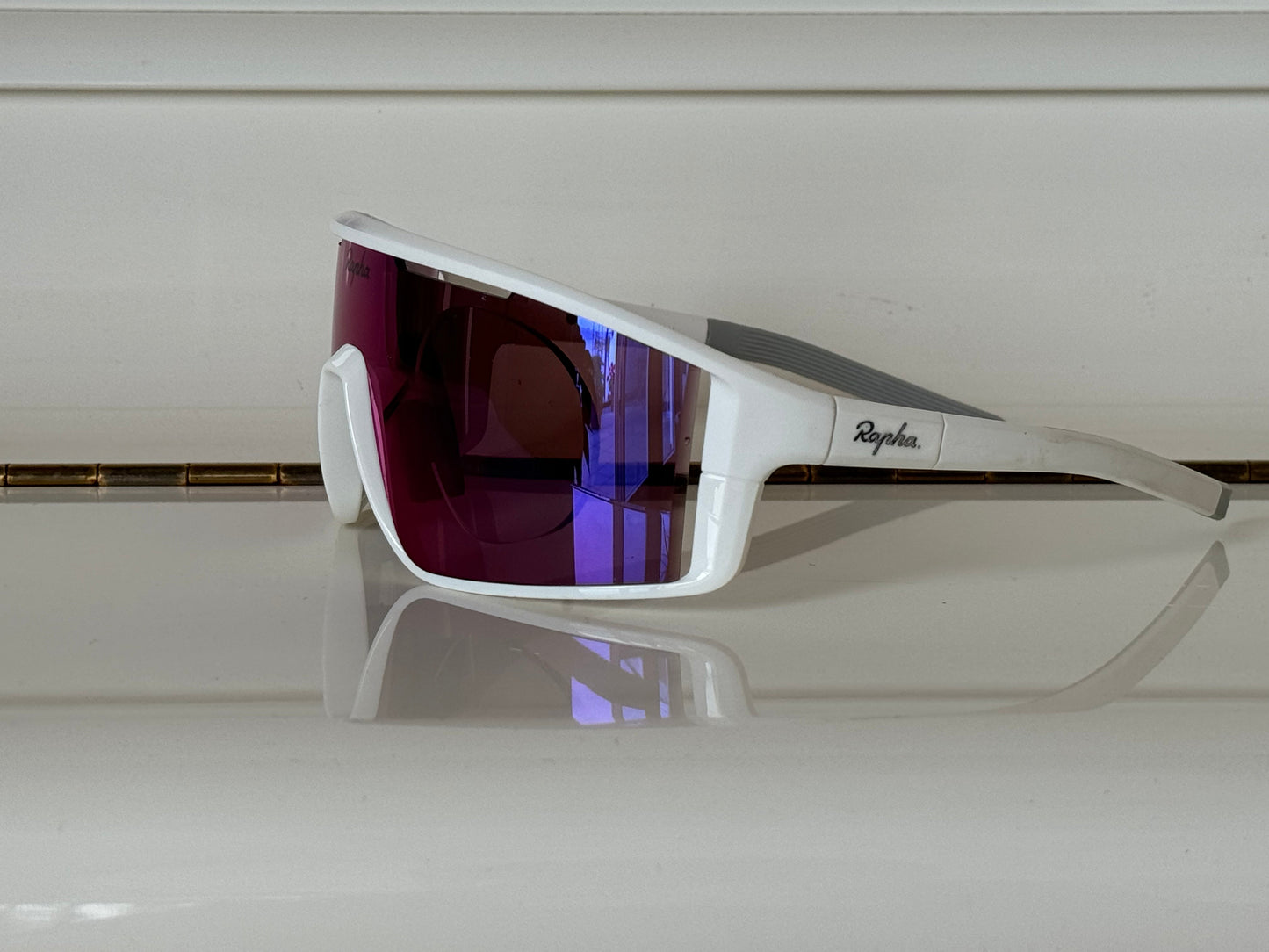 Rapha Fuori cycling glasses, white frame with purple-blue mirrored lens, profile view