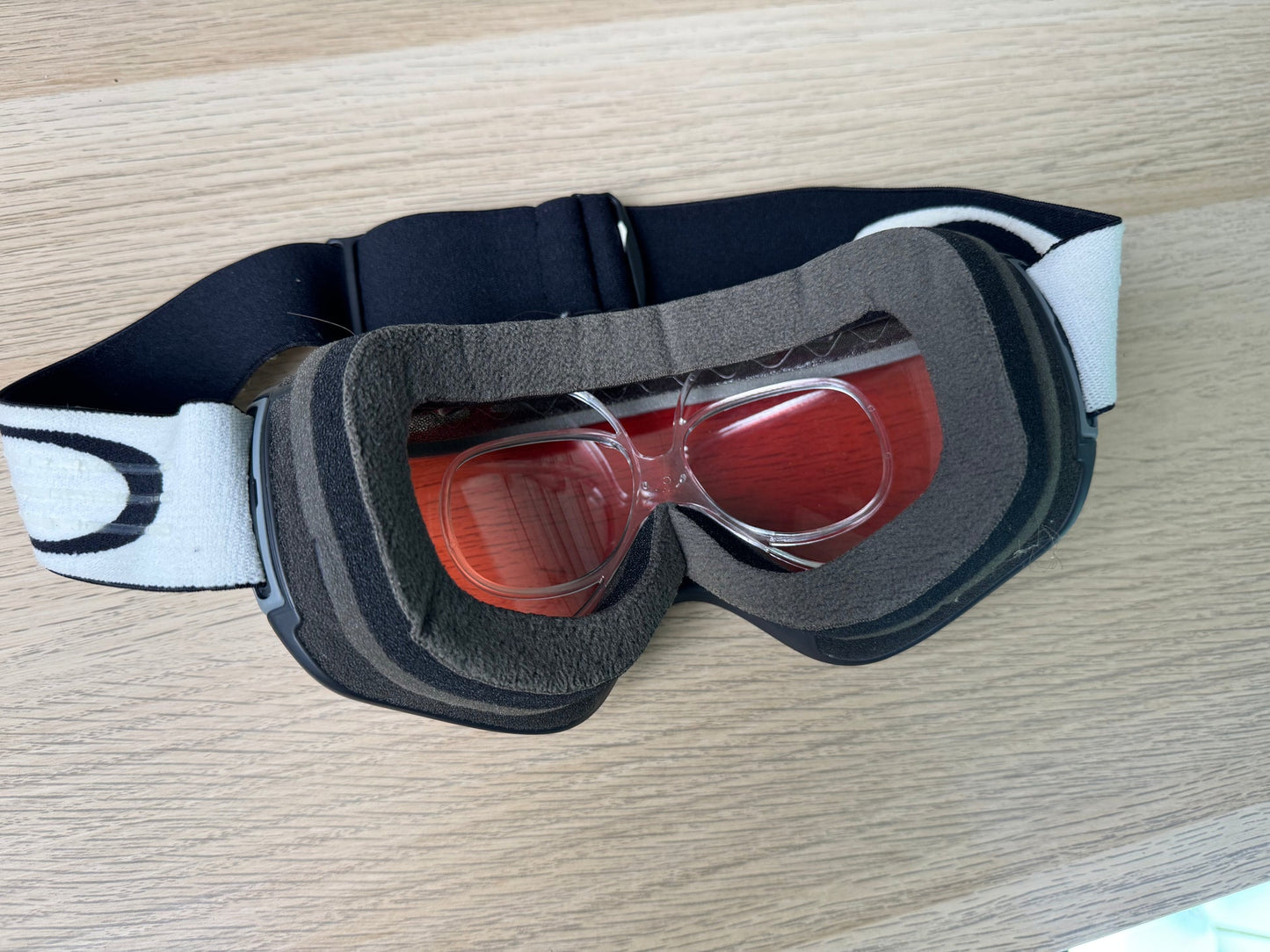 Oakley Flight Tracker ski goggle from face side showing prescription insert installed, red lens