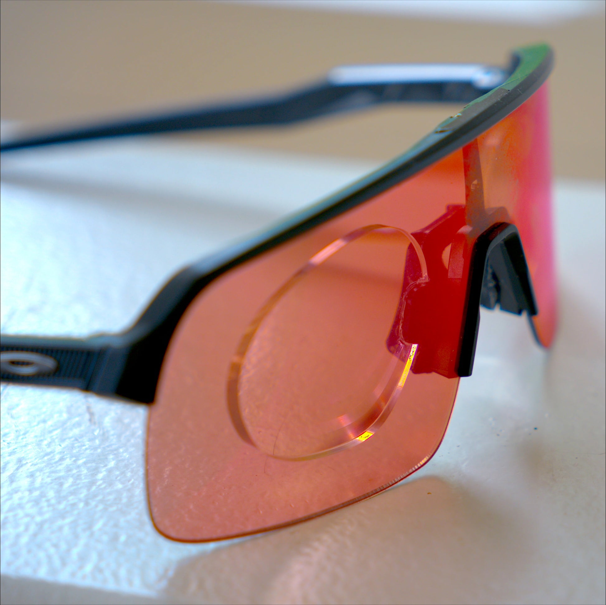 Side angle view of Oakley Sutro Lite with prescription insert, black frame, red Prizm Road lens