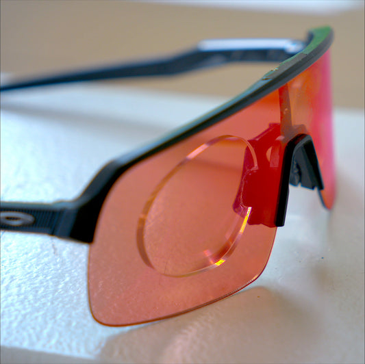 Side angle view of Oakley Sutro Lite with prescription insert, black frame, red Prizm Road lens