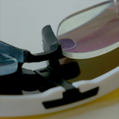Macro close-up of Oakley Sutro Lite S prescription insert clip mechanism attaching to nosepiece bracket
