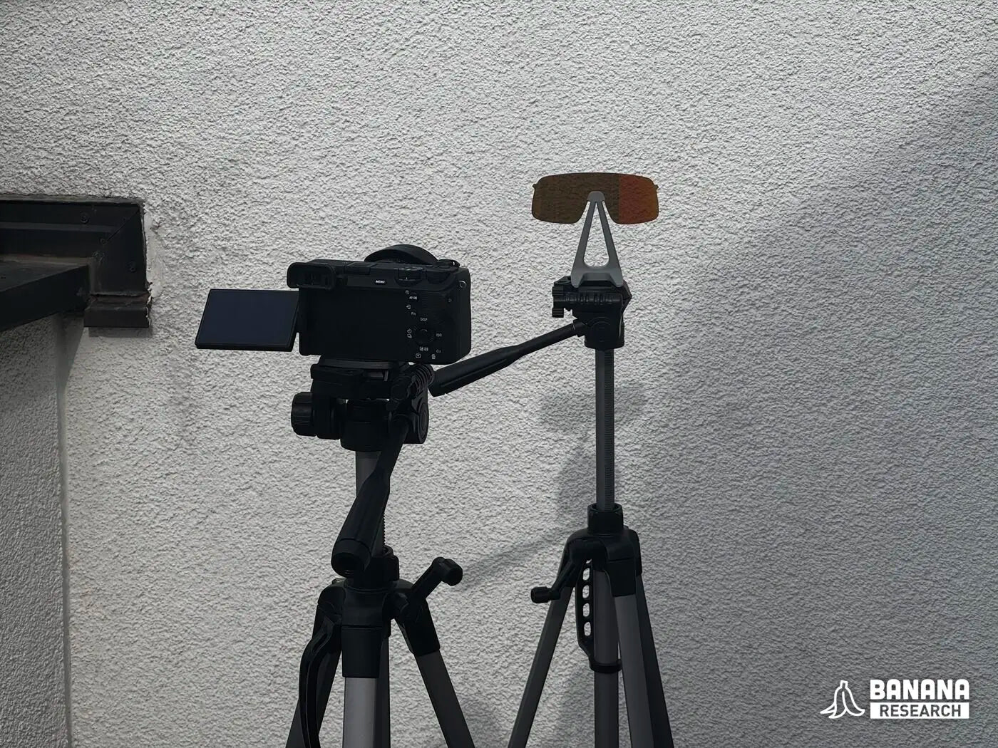 Side view of the camera tripod and the specimen stand in front of the wall
