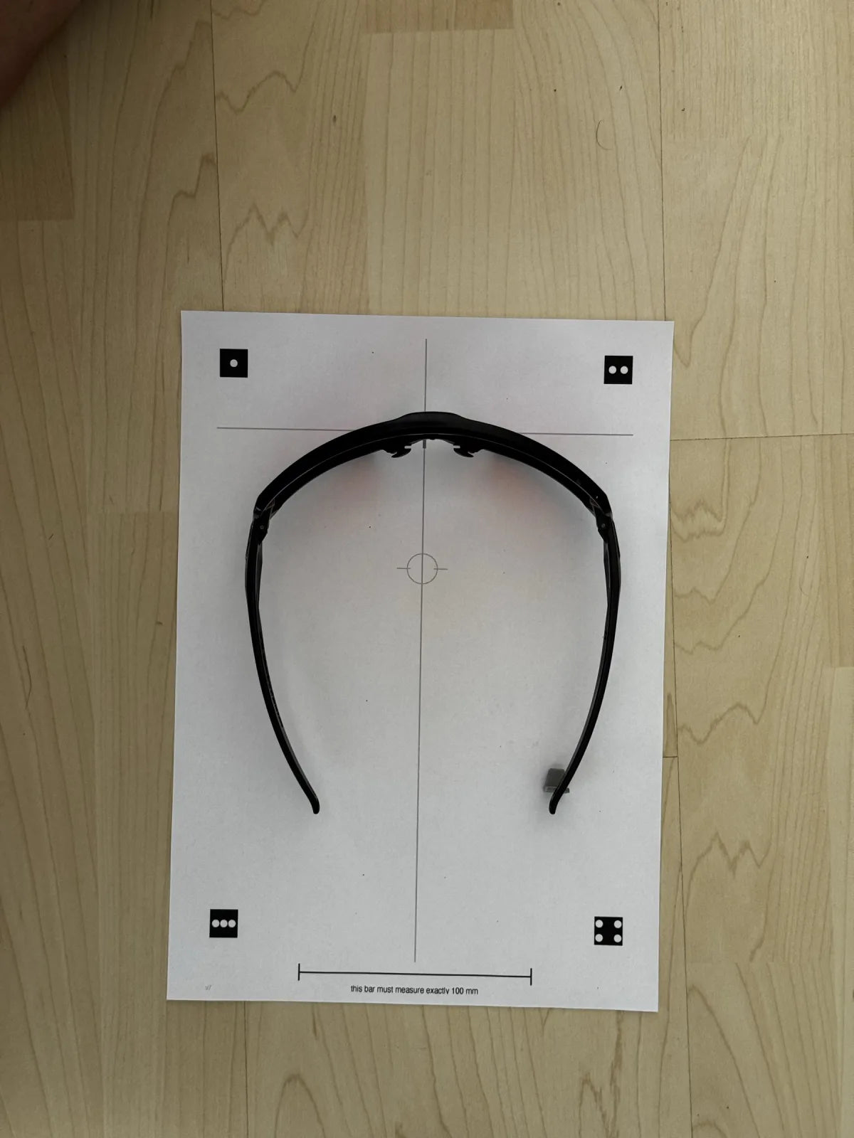The printed reference mat with its bridge cross, 100 mm scale bar and four dot coded fiducials