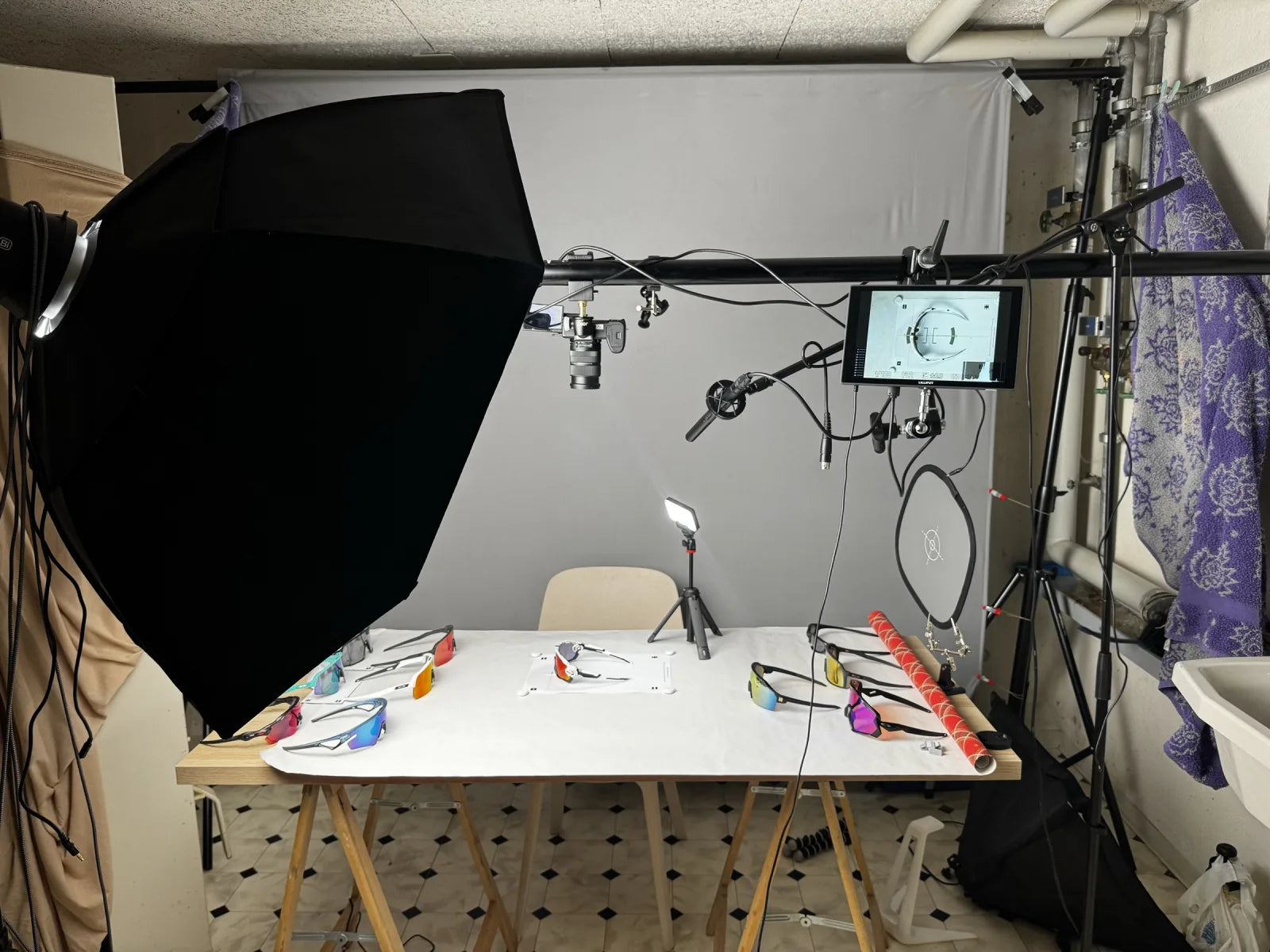 The full shooting station: softbox, backdrop, and the frame collection laid out on the table