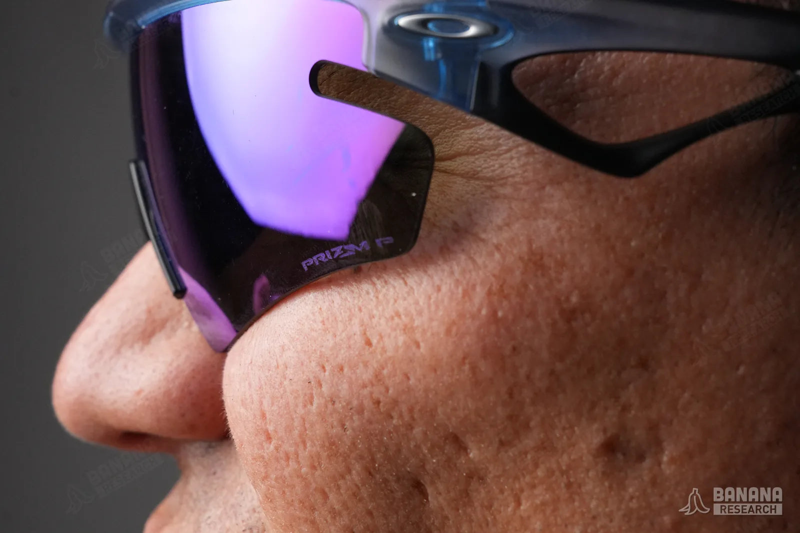 Worn, squinting, showing contact at the cheek